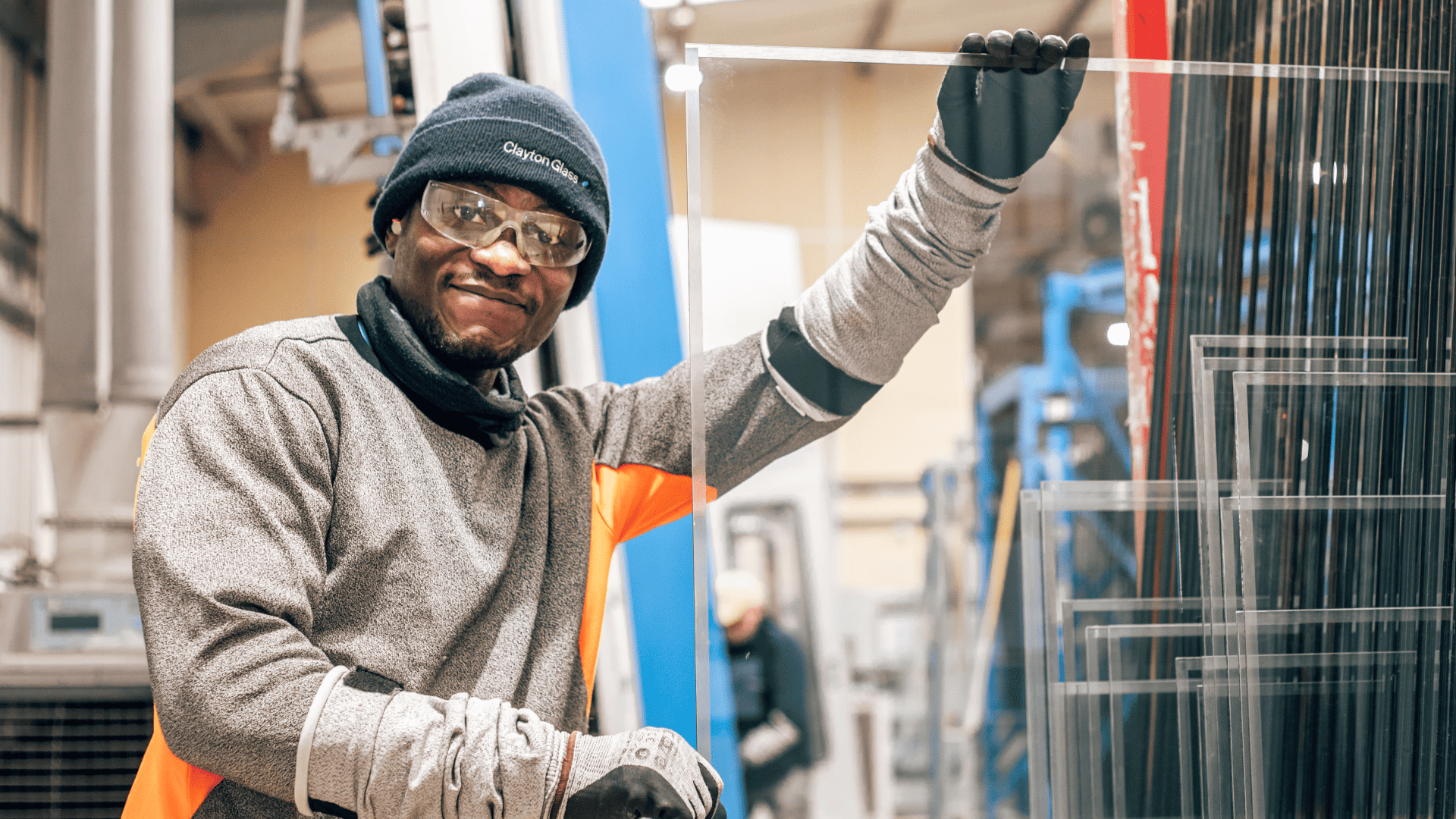 The Clayton Glass Technical Hub contains the collective knowledge of the Clayton team. Pictured is a Clayton Glass employee posing with some glass. 